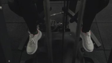 Uzman bir bacak makinesinde bacak kaçıran bir kadının bacakları ön planda..