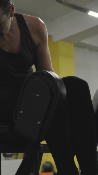 Vídeo Vertical Mujer Joven Luchando Para Ajustar Máquina Secuestros Piernas — Vídeo de stock