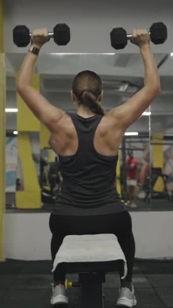 Vídeo Vertical Mujer Atlética Joven Sentada Banco Gimnasio Haciendo Prensas — Vídeo de stock