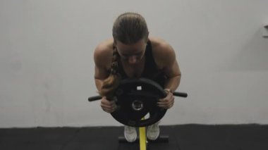 Sırtın gelişmesi için egzersiz. Genç bir kadın spor salonunda ekstra ağırlıkla hiperuzatma egzersizi yapıyor..