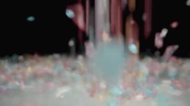 Beyaz Cam Masa 'da, Renkli Şeker serpiştirilmiş, Parlak Kristaller Tatlı Yığını oluşturuyor. Dolly sürgülü yakın çekim. Yavaş çekim