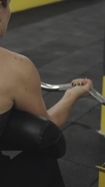 비디오 특별한 기계에 여자는 그립으로 바벨을 그녀의 양서류 근육을 — 비디오