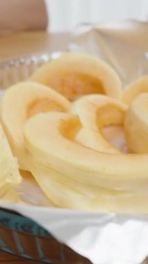 Dikey video. Bir kadın özel bir sebze bıçağıyla balkabağının derisini yüzüyor..