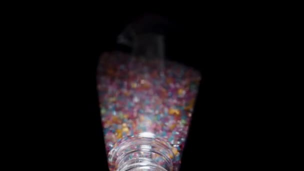 Sokszínű Cukor Díszítésére Péksütemények Ömlik Egy Üveg Egy Fekete Háttér — Stock videók