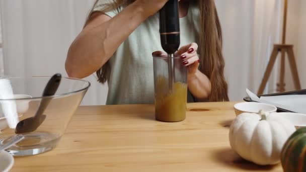 Backdrop White Interior Young Woman Makes Pumpkin Puree Using Blender — Stock Video