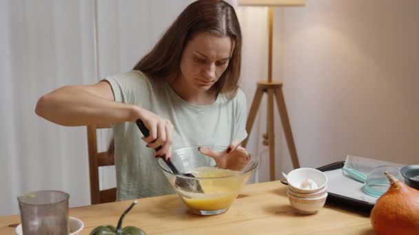 パンプキンクッキーの原料 若い女性が家の雰囲気で準備し 生地をかき混ぜる — ストック動画