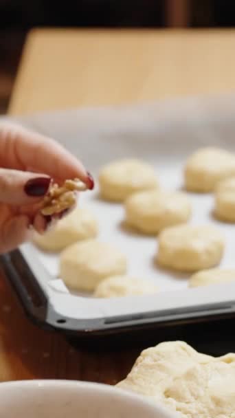 バーティカルビデオ 女性はクッキーごとにクルミを置きます クッキーレシピ — ストック動画