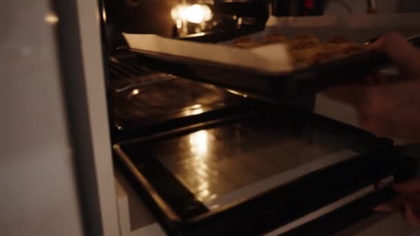 クッキーとクルミでベーキングシートを焼くためにオーブンに置きます — ストック動画