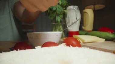 The Woman Places Marul Salatası, Hamburgerin üstüne Yapraklar ve Kamera Geriye Dönüyor. Dolly kaydırıcı aşırı yakın çekim.