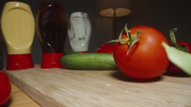 Sebzeler ve soslar masanın arkasında hamburger için. Kamera bitmiş hamburgerlerin üzerinde hareket ediyor. Sağlıklı ve fast food değil. Dolly kaydırıcı aşırı yakın çekim.