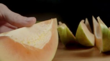 Çekirdeksiz papaya etine parmağımla dokunuyorum, siyah bir arkaplanda, yakın planda..