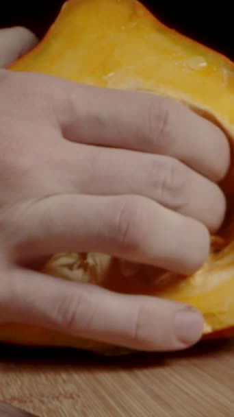 Pionowe Wideo Męska Ręka Bezwzględnie Wyciąga Nasiona Małej Dyni Hokkaido — Wideo stockowe