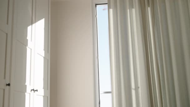 清晨的阳光透过大楼到天花板的窗户照亮了卧室 厚重的窗帘只允许一束微光穿透房间 — 图库视频影像