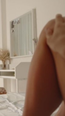 Dikey video. Parlak ve güzel bir iç mekanı olan yatak odası, yatakta bir erkek ve bir kadın. Kucağında dizüstü bilgisayarla çalışırken ya da ders çalışırken, adam onun dizini okşuyor. Adamın bakış açısından bak, yavaş yavaş panoramik bir şeye dönüşüyor.