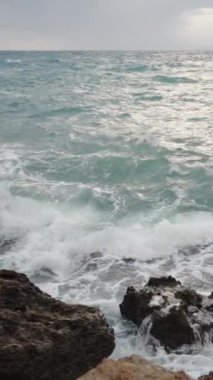 Dikey video. Büyük dalgalar kayalara çarpar, ve bana doğru yükselir, bir deniz fırtınası. Yavaş Çekimde.