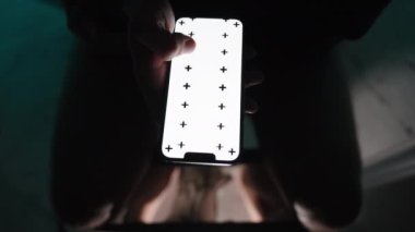 Gece tuvaletteyken, bir adam Beyaz Ekran ve İzleme İşaretleri 'nin planıyla akıllı telefonuyla bir görüntü aktarıyor. Boşluğu Kopyala.