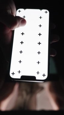 Dikey video. Gece tuvaletteyken, bir adam Beyaz Ekran ve İzleme İşaretleri 'nin planıyla akıllı telefonuyla bir görüntü aktarıyor. Boşluğu Kopyala.