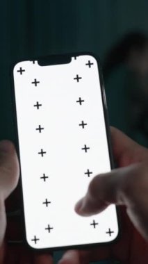 Dikey video. Kadın bilgisayarla uğraşırken, Erkek Gece Yatak Odasında Yatar. Akıllı Telefon Ekranı 'na parmağıyla yazı yazıyor. Smartphone in Hand 'deki Chroma Key Düzeni. Bakış açısı.