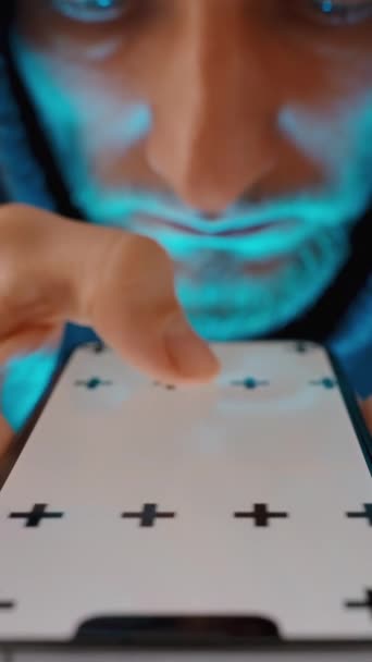 Pionowe Wideo Niebieskie Światło Ekranu Smartfona Oświetla Twarz Młodego Człowieka — Wideo stockowe