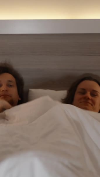 Pionowe Wideo Para Mężczyzna Kobieta Łóżku Wyłaniającym Się Spod Kołdry — Wideo stockowe