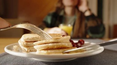 Sunlight 'ta bir kafede kahvaltı, Honey ile krep kesiyorum, yakın plan. 