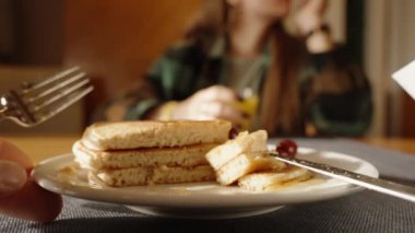 Bal ile Krep Üzerine Düşen Güneş Işıklarıyla Bir Restoranda Kahvaltı. Arka planda Juice 'lu bir kadın var. Yakın plan.