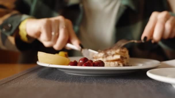 一个女人用巧克力切了一大块煎饼放进嘴里 在餐馆吃早餐 — 图库视频影像