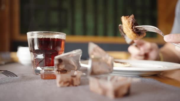 在餐馆里吃早餐 煎饼配巧克力和热茶 把空巧克力包装纸放在桌上 男人的手的特写 — 图库视频影像
