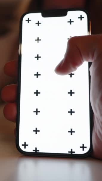 垂直录像 智能手机与一个模拟的白色屏幕和跟踪标记 一个男人在屏幕上扫视 旁边是一杯香槟 后面是一个女人 — 图库视频影像