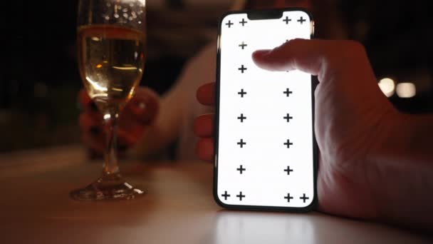 Aku Bergulir Smartphone Saya Sementara Perempuan Minum Sampanye Restoran Malam — Stok Video