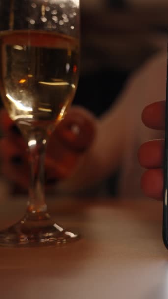 垂直录像 我在智能手机上打滚 而女人则在一家晚餐厅里喝香槟 手持智能手机上的Chroma键模拟 — 图库视频影像