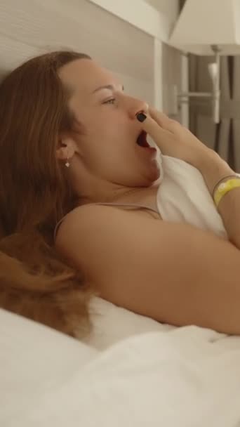 Pionowe Wideo Młoda Kobieta Obudziła Się Ziewała Leżała Lekkim Łóżku — Wideo stockowe