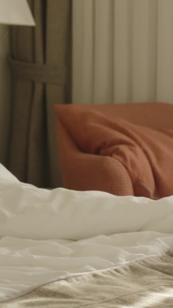 Вертикальное Видео Молодая Женщина Лежит Белой Кровати Улыбается Смотрит Телевизор — стоковое видео