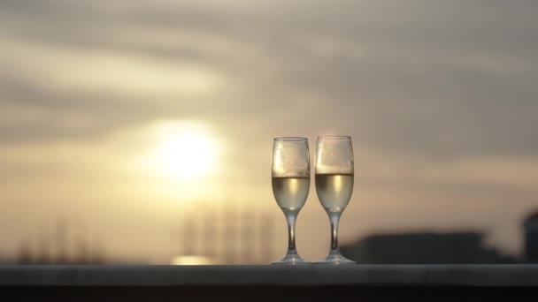 两杯香槟 浪漫的夜晚 背景中的日落 照相机四处转悠 太阳镜中的倒影 — 图库视频影像