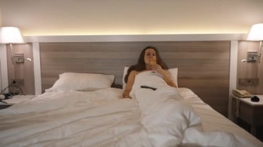 Gece Atmosferi, Lambalar bir kadının yattığı, şampanyamızı yudumladığı ve televizyon izlediği yatağı aydınlatıyor..