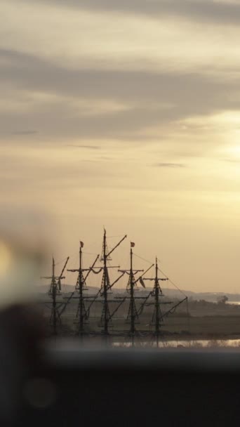 垂直录像 垂直录像 一位女士带着一杯葡萄酒走上巴尔科尼号 欣赏旧船和海上落日的美景 — 图库视频影像