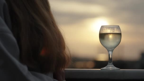 Szklanka Wina Stoi Balkonie Zbliżeniu Odzwierciedlając Promienie Zachodzącego Słońca — Wideo stockowe