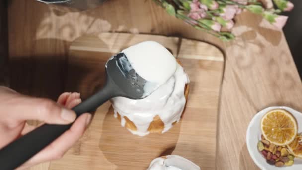トップビュー 女性がホワイトアイシングで自家製イースターケーキをカバー — ストック動画