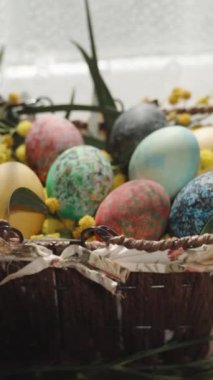 Dikey video. Beyaz kremalı ev yapımı kekler masaya damlıyor, Paskalya yumurtaları da yakınlarda. Arka planda, Güneşli Pencere.