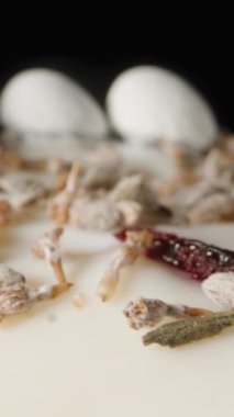 Dikey video. Çikolata kalpli beyaz kremalı Paskalya pastası ve üstünde küçük yumurtalar. Dolly kaydırıcı aşırı yakın çekim.