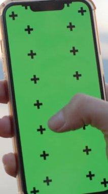 Yeşil Ekran ve İzleme İşaretleyicili Akıllı Telefona Odaklanma Efekti. Deniz kıyısındaki yüksek uçurumdaki kadın. Ekleme için Yerleşim.