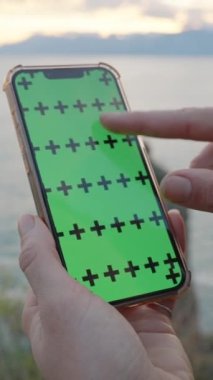 Yeşil Ekran Modelleri ve İzleme İşaretleri olan akıllı telefon, Ekranda Pinch Zoom Hareketi, Harita veya Görüntü Kavramı. Denizin Arkaplanına Karşı Kadın El.