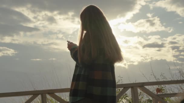 Pohled Zpoza Ženy Kostkované Košili Držící Telefon Zatemňující Slunce Oblacích — Stock video