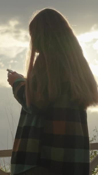 Pohled Zpoza Ženy Kostkované Košili Držící Telefon Zatemňující Slunce Oblacích — Stock video