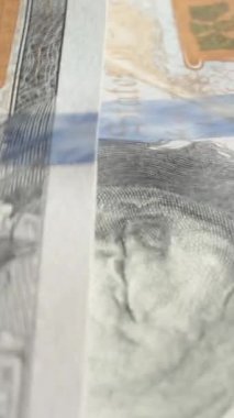 Dikey video. Arasında 20 'likler olan 100 Dolarlık banknotlar sayılıyor. Yakın plan.