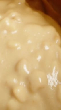 Dikey video. Fıstık Ezmeli Karıştırılmış Fıstık Ezmesi 'nin Üst Görünümü Kaşık Kullanımı, Yavaş Çekim Makro, Kaypak.