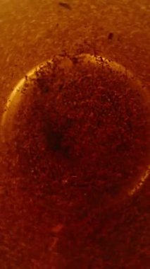 Dikey video. Çay karışıyor ve çay yaprağı parçaları içeride toplanıyor. Yavaş çekim, yakın çekim. Düşük açı görünümü pencereye odaklan