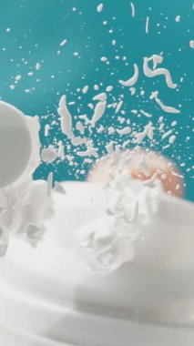 Dikey video. Bir erkek tıraş köpüğü sürer. Söndü ve biraz daha sıkmak için şişeyi salladı. Aşağıdan mavi arkaplana bak. Düşük açı görünümü pencereye odaklan