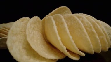 Masaya saçılmış eyer şeklinde mısır cipsleri ve kamera aralarından süzülürken onları birer birer topluyorum. Dolly kaydırıcı, kapat..