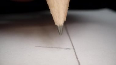 Bir el tarafından tutulan ve kağıda bir şeyler yazan bir kalemin yakın çekimi. POV.